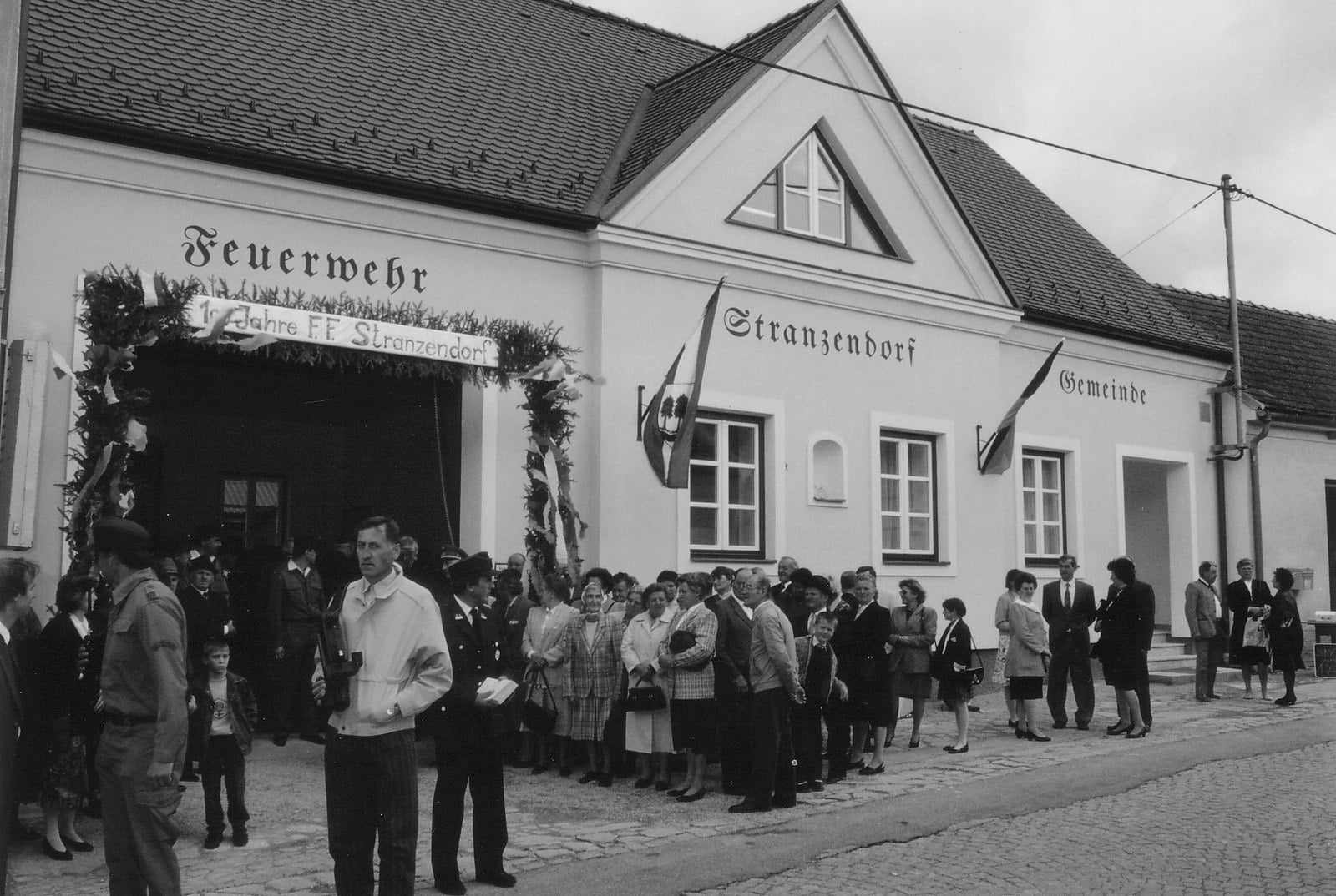 Das neue Feuerwehrhaus mit Banner „100 Jahre F.F. Stranzendorf“ und Ortsbevölkerung, 1992